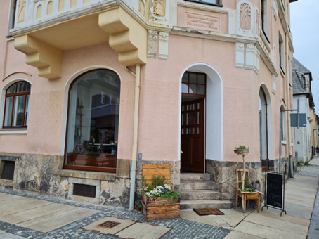 Charmante Café-Außenansicht in einem historischen Gebäude.